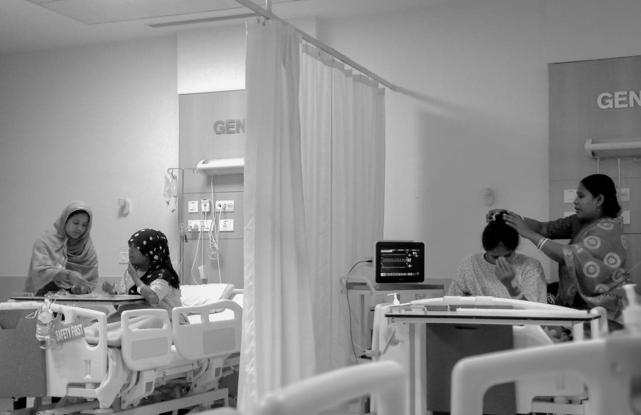 Women caring for patients in a Kolkata, WB, India, hospital room, focusing on recovery.